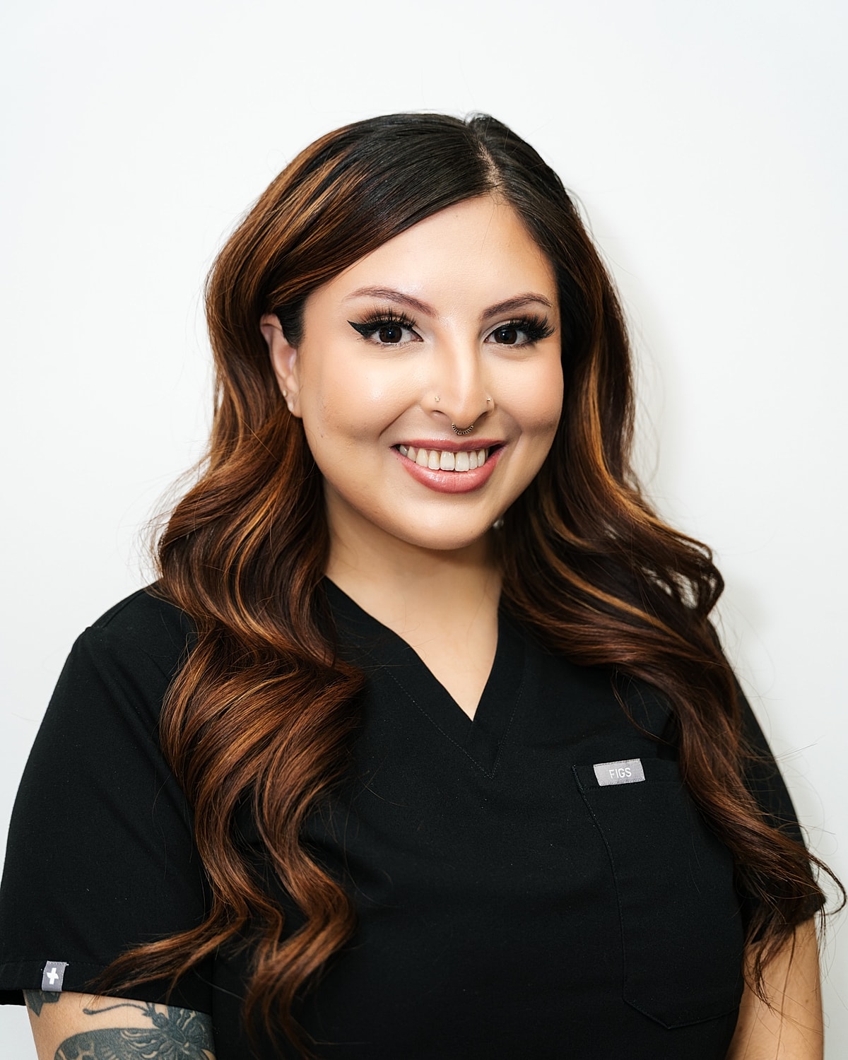 Smiling woman in medical scrubs against white background