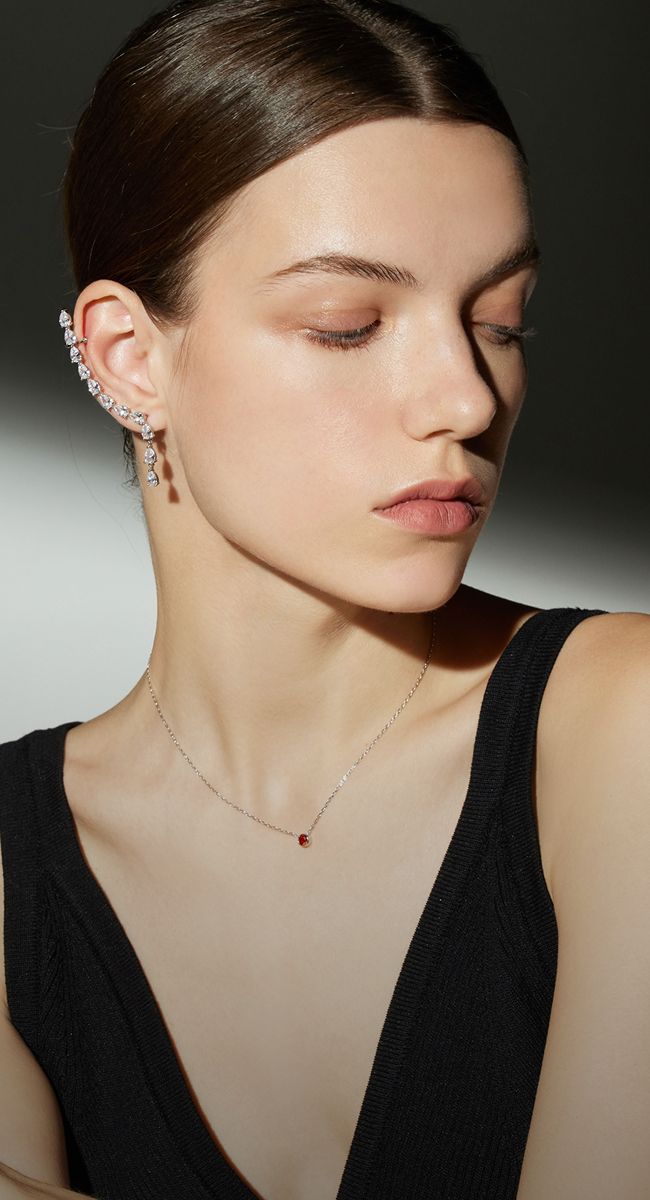 Model wearing elegant jewelry with natural makeup.