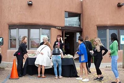 People gathering at an outdoor event table.
