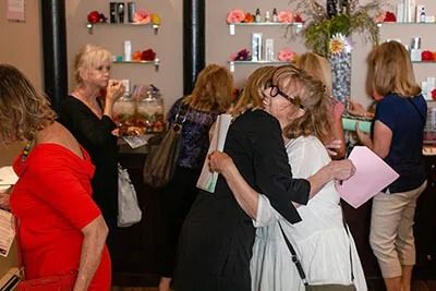 Women socializing and hugging at an event.