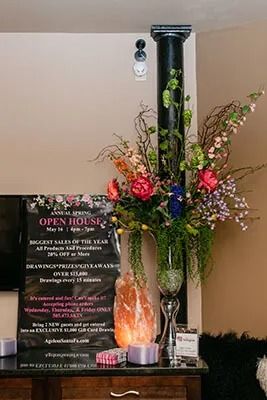 Floral arrangement beside an open house sign.