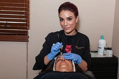 Cosmetologist performing skincare treatment on client.