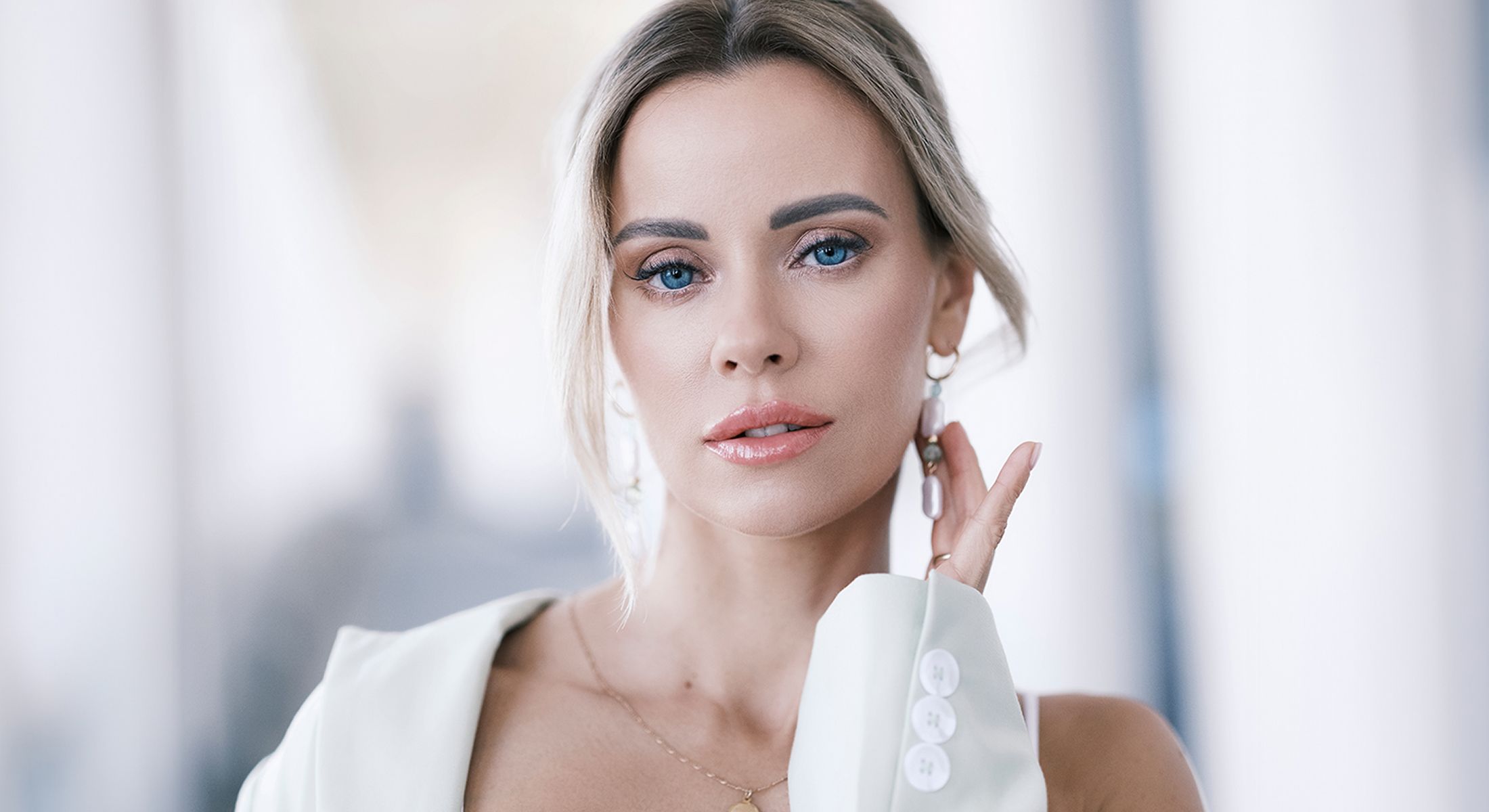 Woman with elegant hairstyle and makeup indoors.