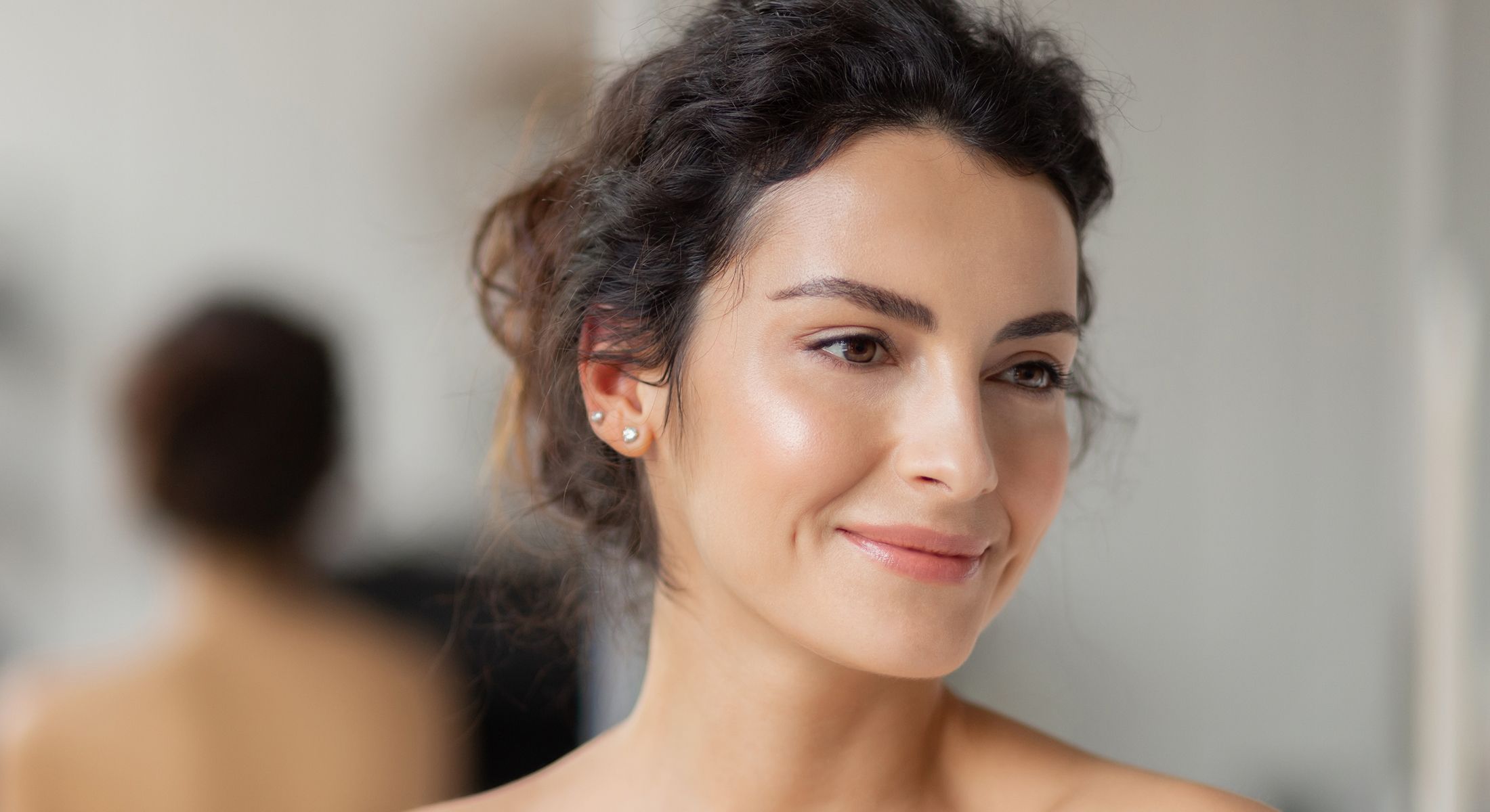 Smiling woman with curly hair in soft lighting