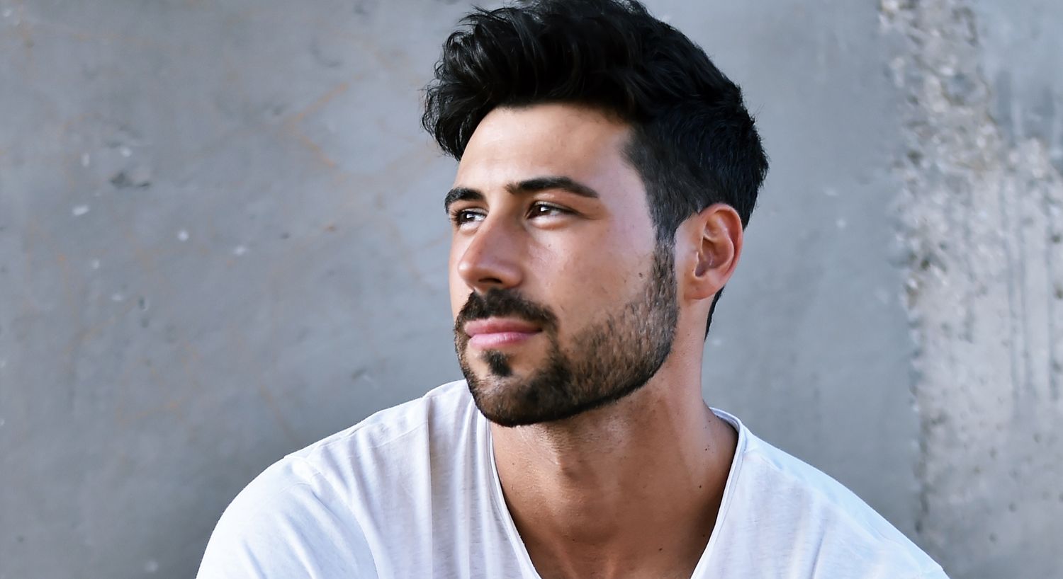Man with facial hair looking thoughtfully to the side.